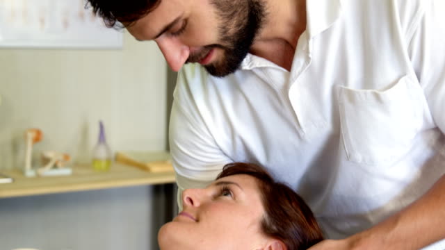 Physiotherapeuten,-die-eine-Patientin-Kopfmassage-verleihen