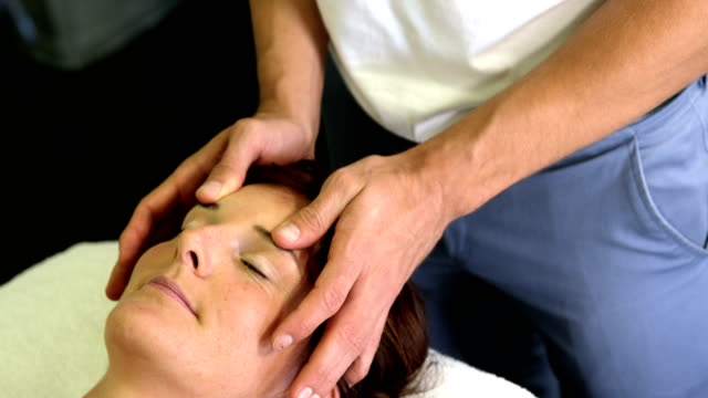 Physiotherapeuten,-die-eine-Patientin-Kopfmassage-verleihen