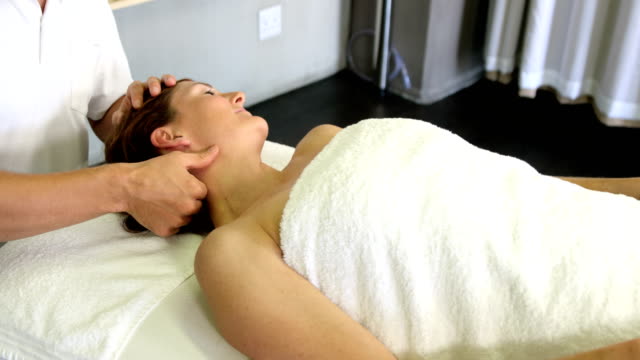 Physiotherapist-dando-masajes-en-el-cuello-de-una-mujer