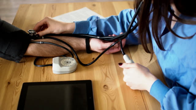 Mujer-médico-medir-la-presión-arterial,-cerca-FullHD