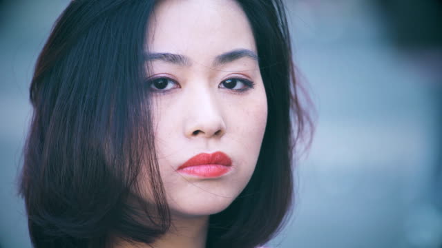 deprimida-y-seria-mujer-China-en-la-ciudad:-Closeup-retrato