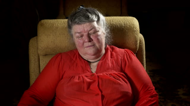 70-year-old-elderly-woman-in-armchair-watching-TV