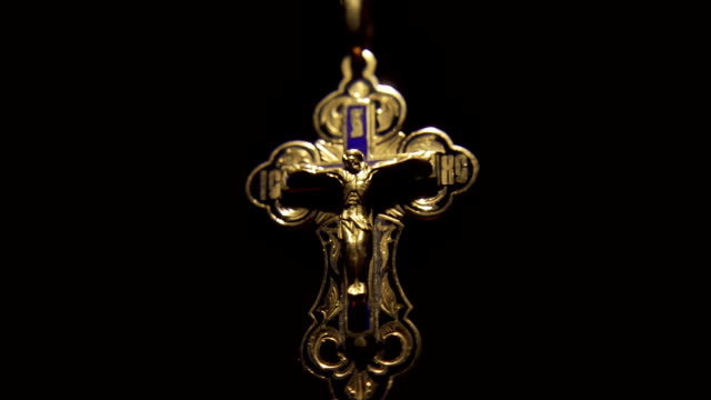 Das-goldene-Kreuz-mit-Jesus-Christus-auf-der-Kette-scheint-aus-der-Dunkelheit