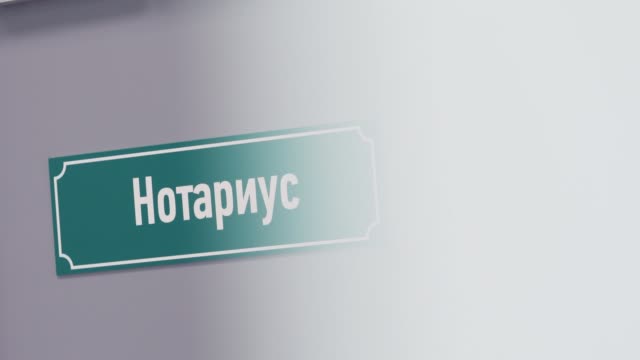 Muestra-plástica-verde-en-la-puerta-con-notario-de-sais-de-texto-en-ruso