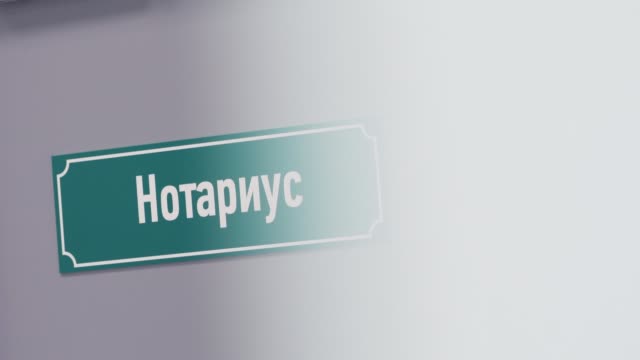Green-plastic-sign-on-door-with-cyrillic-text-sais-notary