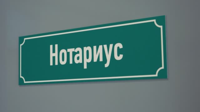 Green-plastic-sign-on-door-with-russian-text-sais-scrivener