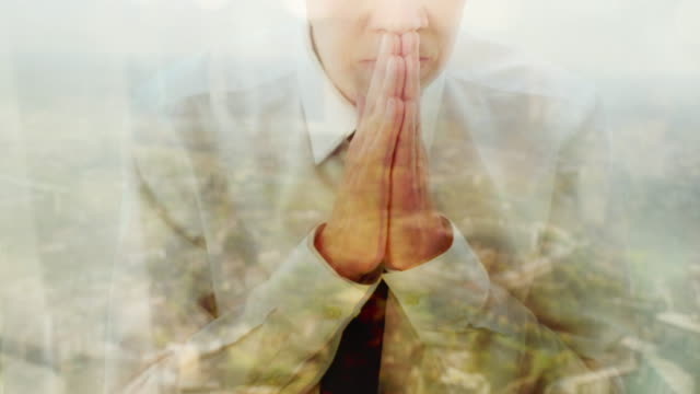 Reflexion-eines-Geschäftsmannes-beten-gegen-ein-Fenster