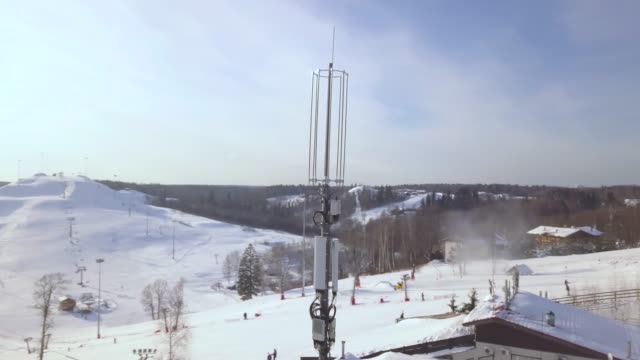 Hoher-Turm-mit-Antennen-für-mobile-Welle-im-Winter-Skigebiet.-Drohne-Blick-Handy-Kommunikation-Repeater-Antenne.-Handy-Netz-Antenne