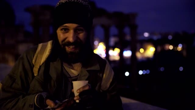 lächelnd-ein-glücklich-Obdachlosen-in-der-Nacht-zeigt-seine-Almosen