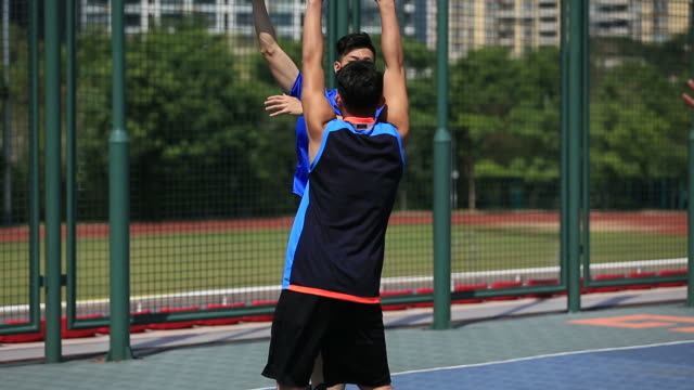 young-asian-adults-playing-basketball-outdoors