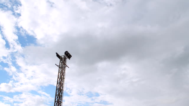 Electric-spotlight-pole-with-blue-sky-background,-time-lapse.