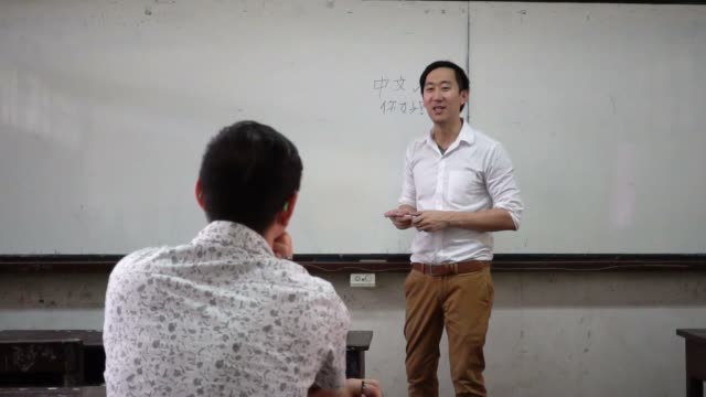 Instructor-de-idiomas-orientales-extranjeros-asiáticos-jóvenes-dando-una-lección-de-lengua-en-el-aula