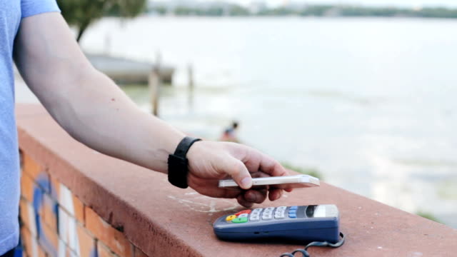 Ein-Mann-macht-eine-Zahlung-mit-einem-Smartphone-und-terminal