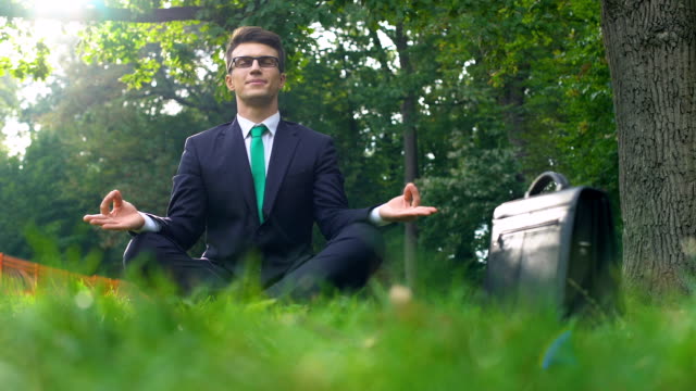 Geschäftsmann-auf-dem-Rasen-sitzen-und-meditieren-an-der-frischen-Luft,-Energie-der-Natur