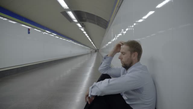 Verzweifelte-traurige-Jungunternehmer-emotionalen-Schmerz-Trauer-und-Tiefe-Depression-allein-sitzen-in-Tunnel-u-Bahn-Stress-Lebensstil-Arbeit-Probleme-scheitern-Arbeitslosigkeit-psychische-Gesundheit-und-Depressionen-leiden.