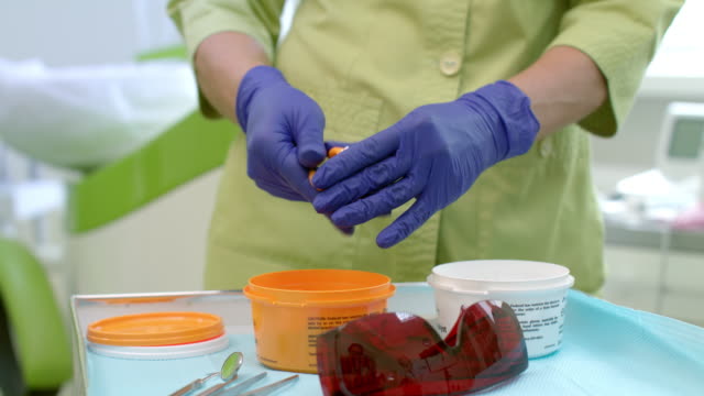 Dental-technician-preparing-material.-Dentist-hands-kneading-silicone