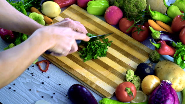 Man-is-chopping-parsley-on-cutting-board
