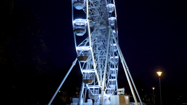 Movimiento-grande-rueda-de-Ferris-en-Brno,-República-Checa-en-Moravske-Plaza-de-lado-durante-la-instalación-para-el-evento-de-Navidad-capturado-en-la-noche