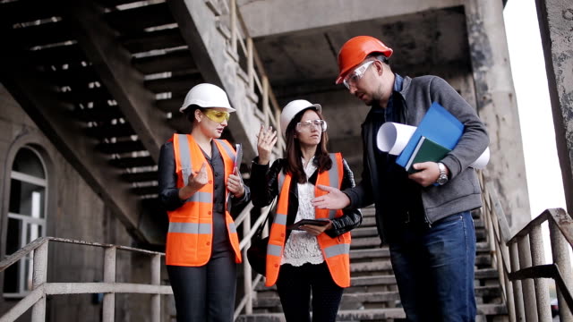 The-foreman-and-two-women-inspectors-to-discuss-the-plan-of-work-performed-on-construction-or-restoration-of-the-building.
