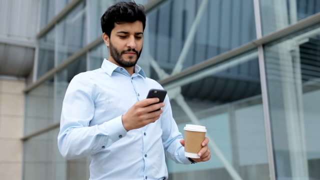 Handsome-Business-Man-With-Phone-And-Coffee-On-Street