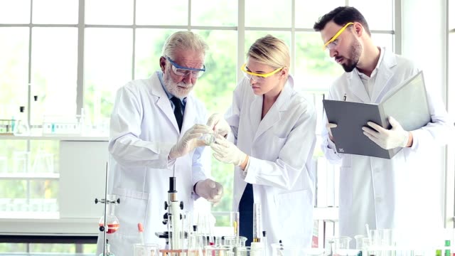 Wissenschaftsteam-Lehrer-und-Schüler-arbeiten-mit-Chemikalien-im-Labor