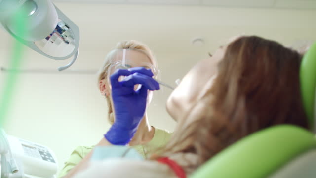 Tapón-de-algodón-que-dentista-mujer-en-abrir-la-boca-de-paciente.-Proceso-de-tratamiento