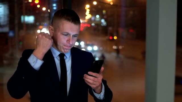 The-man-is-a-businessman,-looking-at-the-smartphone-and-angry,-trying-to-contain-anger.