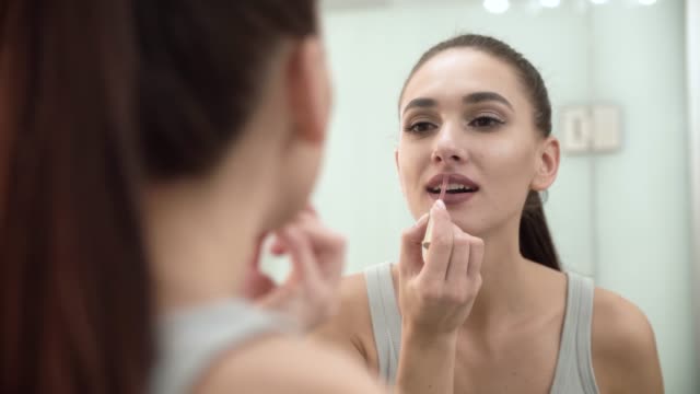 Makeup.-Woman-Applying-Liquid-Lipstick-On-Lips-At-Bathroom