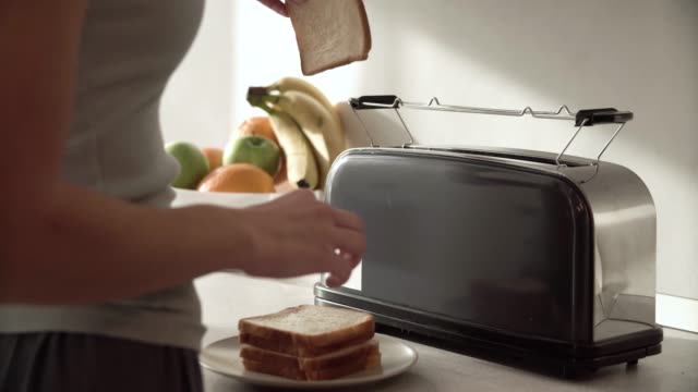Frühstück.-Frau,-setzen,-schneiden-Brot-im-Toaster-Closeup