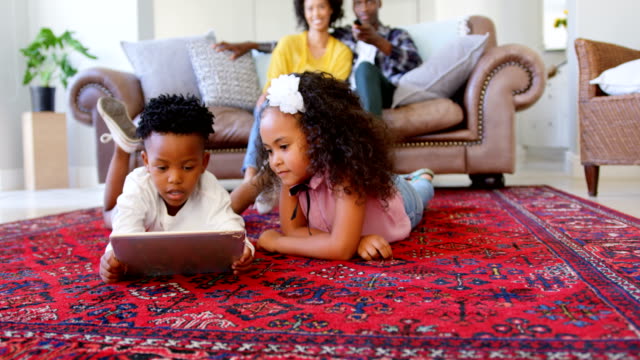 Vorderansicht-des-niedlichen-schwarzen-Kinder-mit-digital-Tablette-in-Wohnzimmer-mit-komfortablen-Zuhause-4k