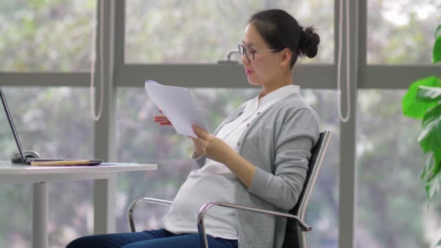 Seitenansicht-der-chinesischen-schwangeren-Geschäftsfrau-arbeitet-im-Büro