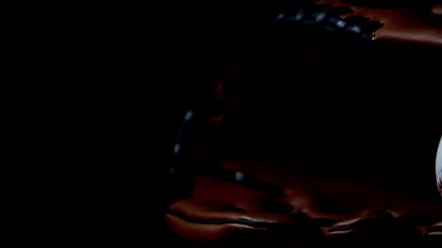 Throw-a-baseball-with-a-baseball-glove,-put-in-a-dark-light