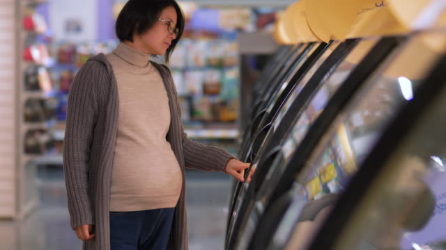 Schwangere-asiatische-Frau-einkaufen-im-Supermarkt