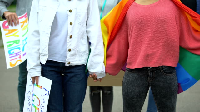 Gruppe-von-Menschen,-die-Regenbogenfahnen-hissen,-Plakate-für-LGBT-Rechte,-Gleichstellung-der-Geschlechter