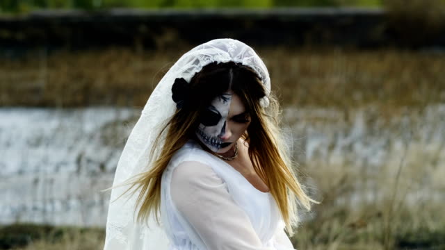 Die-junge-Frau-mit-gruseligem-Make-up-für-Halloween-in-einem-weißen-Brautkleid.-4K