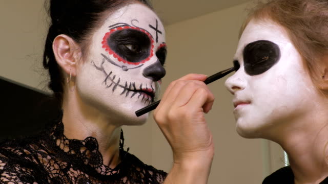 Mother-and-daughter-apply-Halloween-makeup