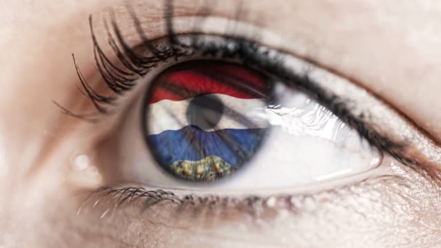 woman-green-eye-in-close-up-with-the-flag-of-Netherlands-in-iris-with-wind-motion.-video-concept
