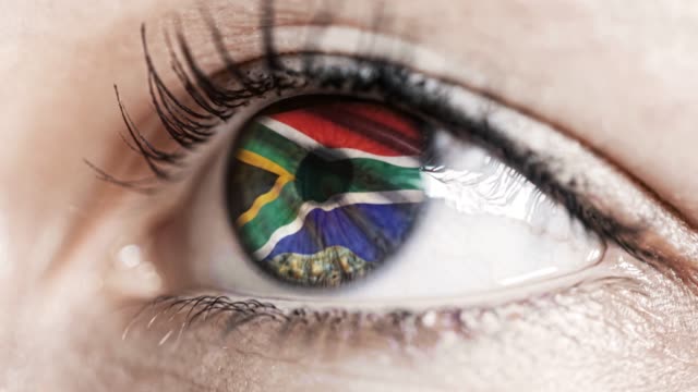 mujer-ojo-verde-en-primer-plano-con-la-bandera-de-Sudáfrica-en-el-iris-con-el-movimiento-del-viento.-concepto-de-vídeo