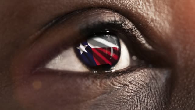 Mujer-ojo-negro-en-primer-plano-con-la-bandera-del-estado-de-Texas-en-iris,-estados-unidos-de-América-con-movimiento-de-viento.-concepto-de-vídeo
