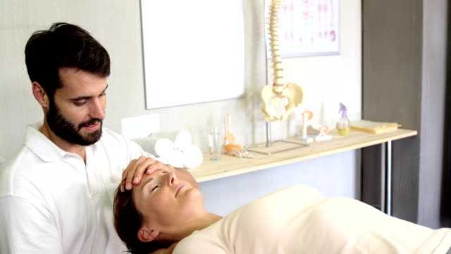 Dar-masaje-a-un-paciente-femenino-de-fisioterapeuta