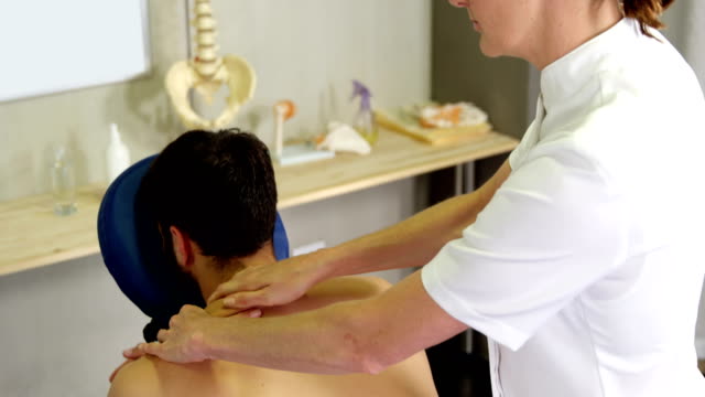 Fisioterapeuta-mujer-dar-masaje-a-un-paciente