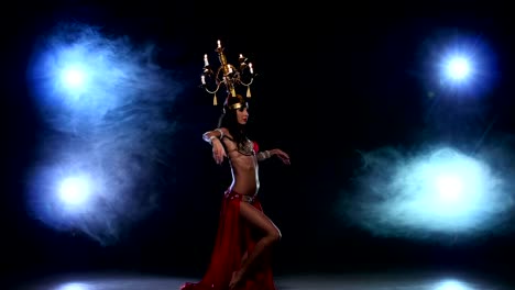 Attractive-belly-dancer-girl-dancing-with-candles-on-her-head,-black,-smoke