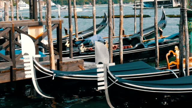Soporte-de-góndolas-negras-hermosas-y-roca-en-las-olas-del-Gran-Canal-en-Venecia