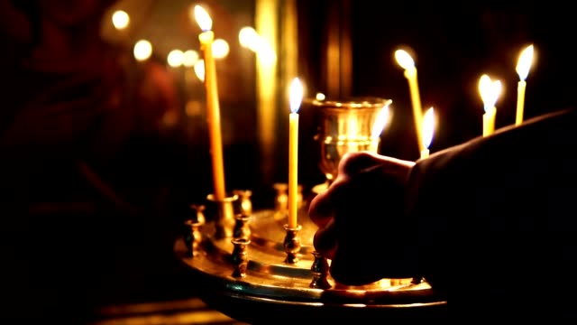 Man-corrects-candles-burning-in-the-candlestick-before-the-Holy-face-in-the-Christian-Church