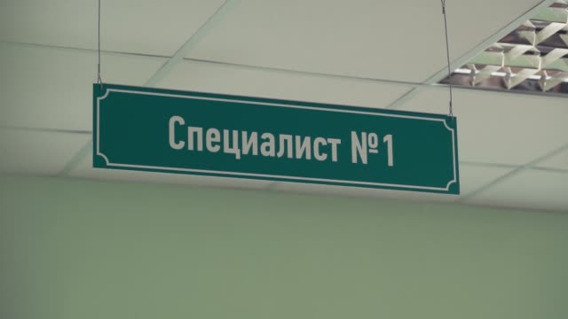 Green-plastic-sign-under-ceiling-with-russian-text-sais-specialist-number-one