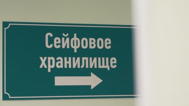 Green-plastic-sign-on-wall-with-russian-text-sais-safe-depository