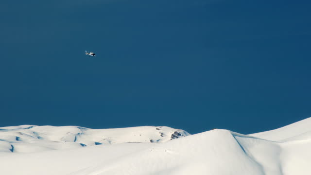 Heliski-helicóptero-vuela-sobre-el-trasfondo-de-las-montañas-nevadas