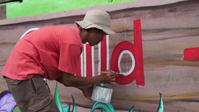 Mural-painter-draws-a-letter-d-on-school-wall.-time-lapse