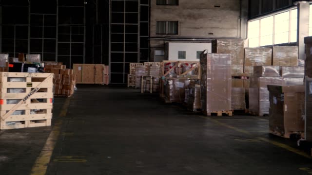 paquetes-y-cajas-en-el-almacén-del-puerto,-dolly