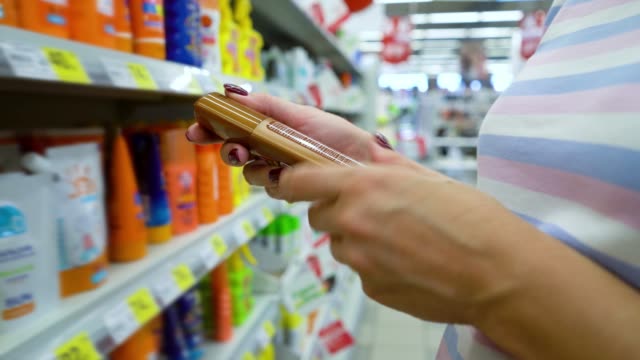 Closeup-caucasian-woman-near-shop-shelves-choosing-cosmetics-in-market
